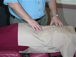 Chiropractor's hands performing a spinal adjustment